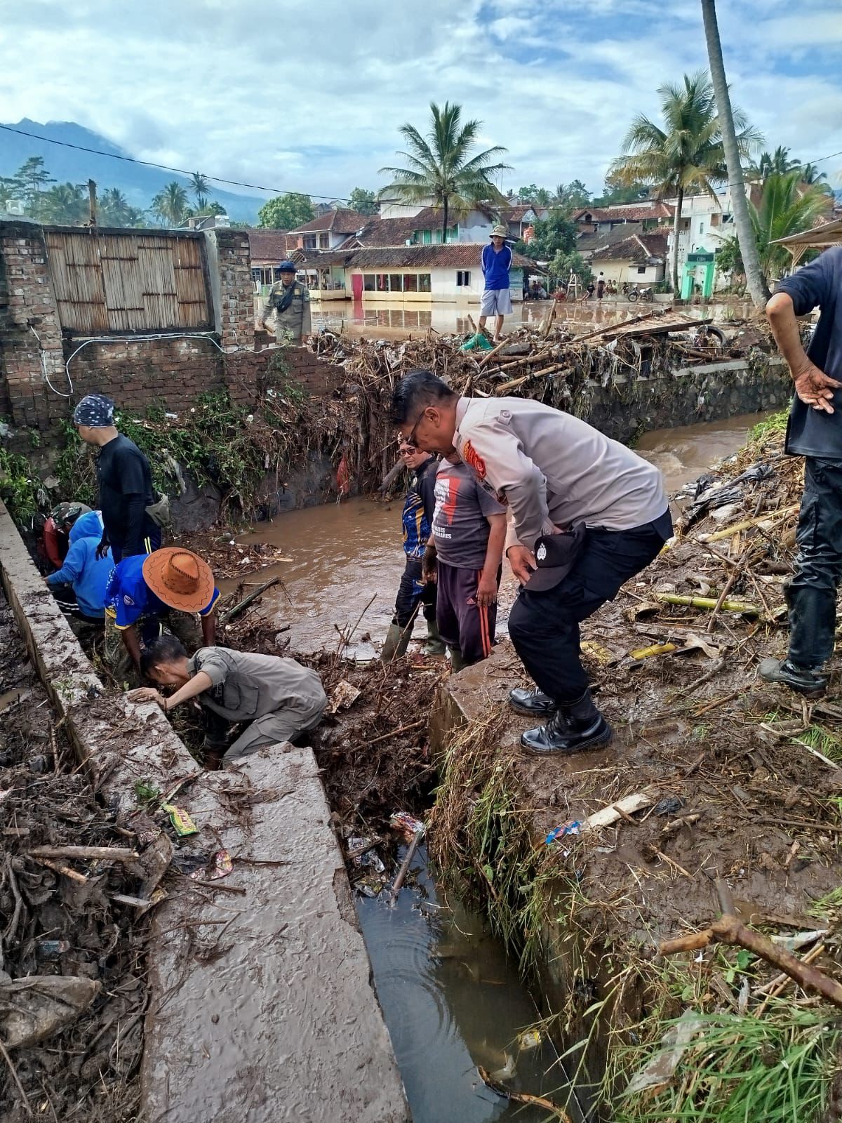 Polsek Sukawening Bersama Forkopimcam dan Warga Gotong Royong Bersihkan Sisa Banjir di Kampung Cipeucang